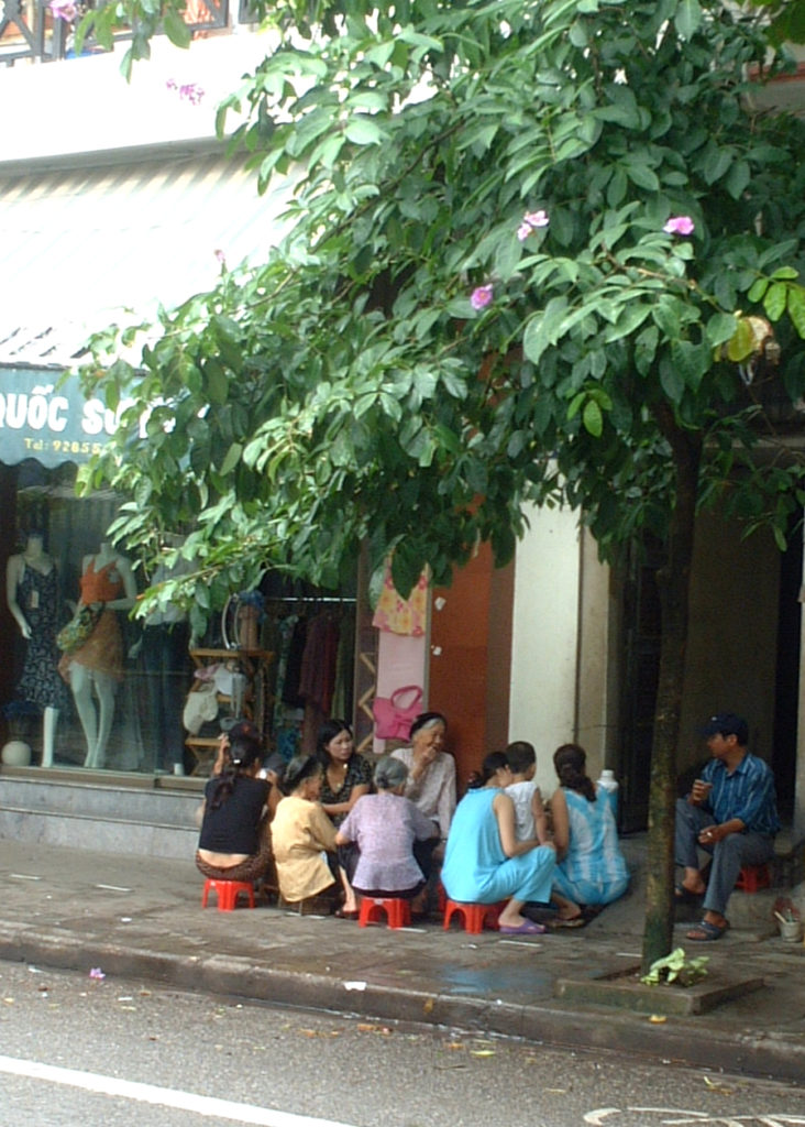 Une groupe de femmes (famille ou voisines) assises dans la rue dans une ville vietnamienne