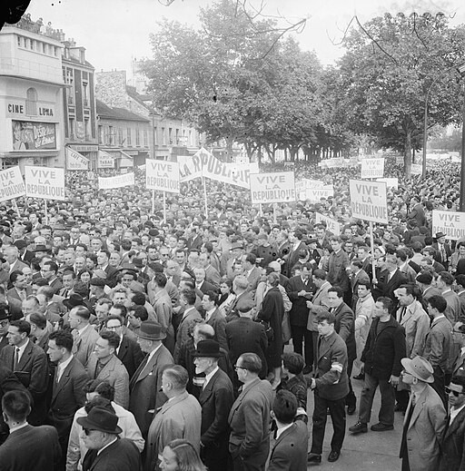 Photo NB d'une manifestation politique de mai 1958 où l'on voit des hommes avec des pancarte affichant le slogan "Vive la République"